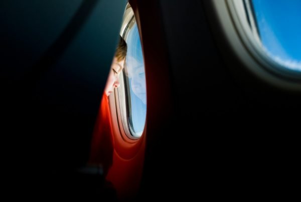 person looking at the window of an airplane